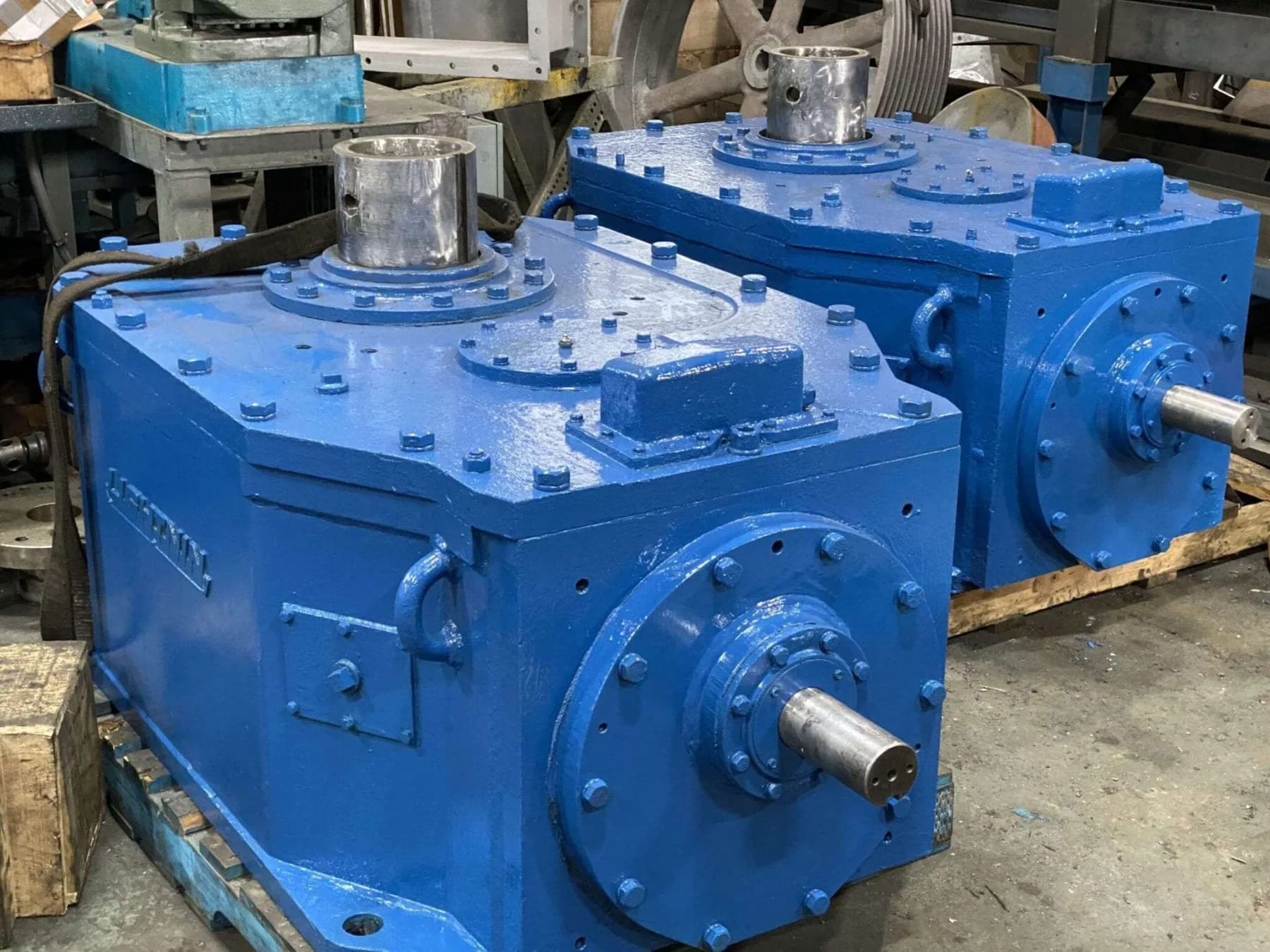 Two freshly painted blue rebuilt industrial gearboxes staged on pallets at Gear Force Machine.