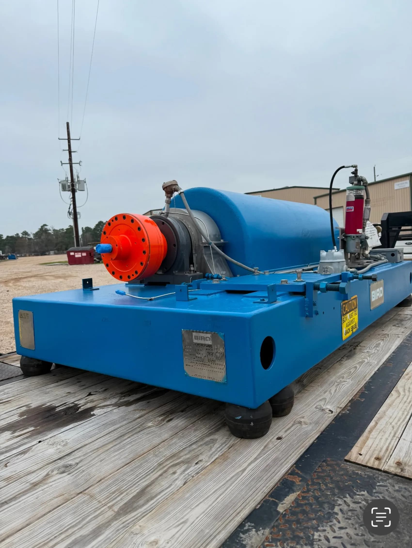 A rebuilt Bird decanter centrifuge in fresh blue paint with an orange backdrive gearbox at the Gear Force Machine shop.