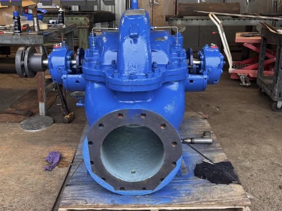 The same split-case centrifugal pump rebuilt and repainted in fresh blue, staged on a pallet in the Gear Force Machine shop.